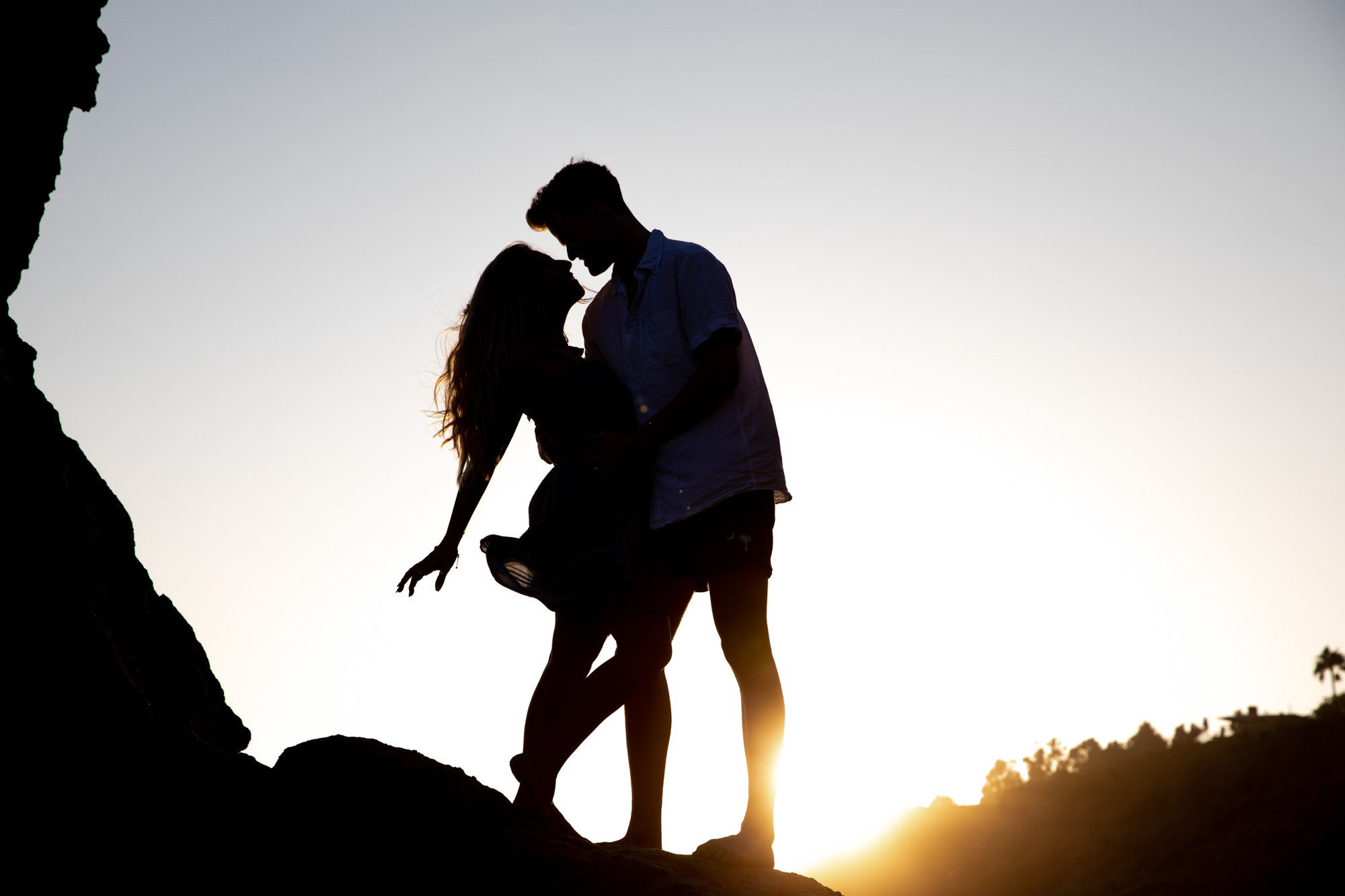 couple poses in silhouette at El Matador Beach in Malibu
