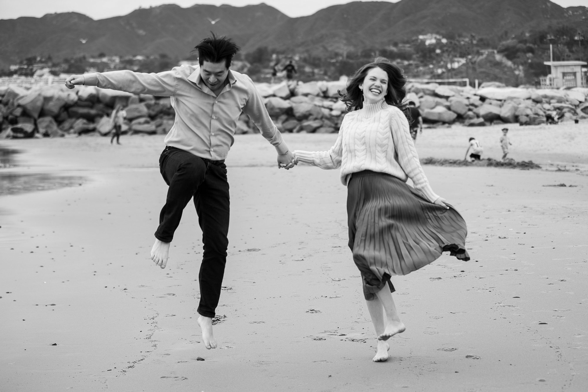 joyful couple skips at will rogers state beach